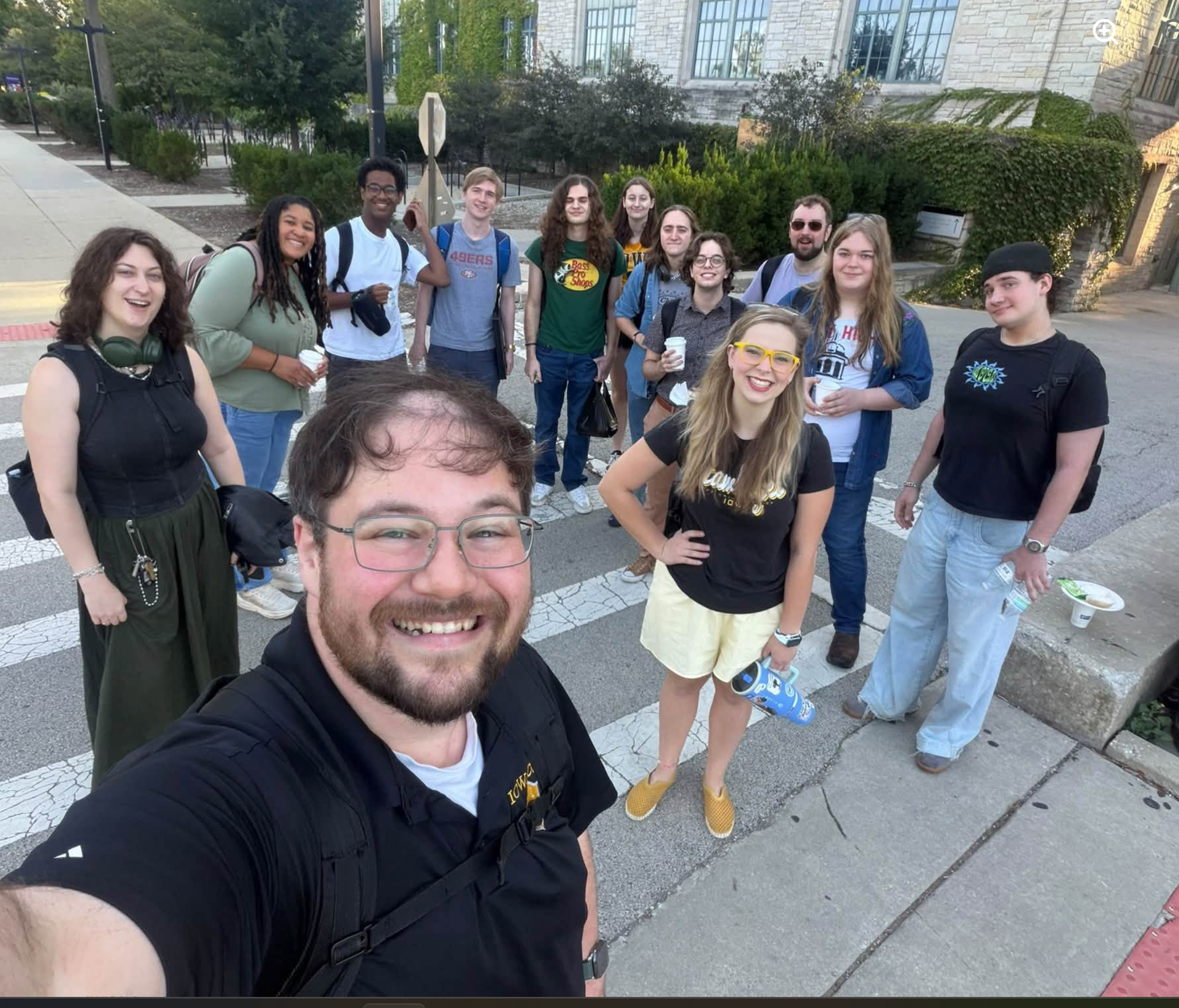 A large group of Iowa debater and coaches standing outside smiling 
