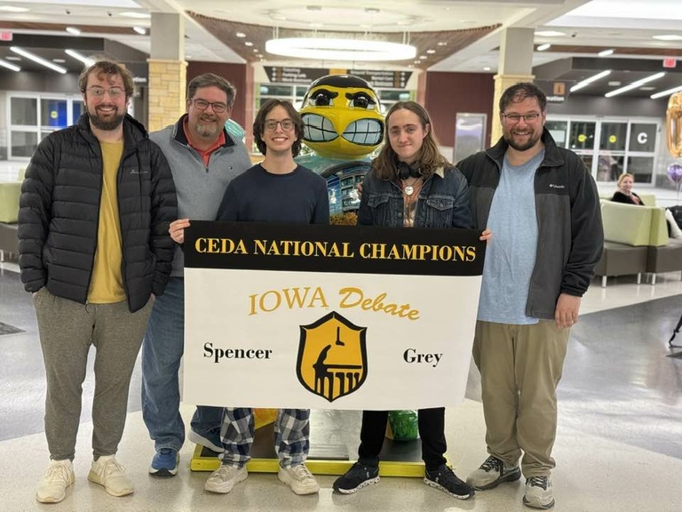 A group of people around a stature of herky 