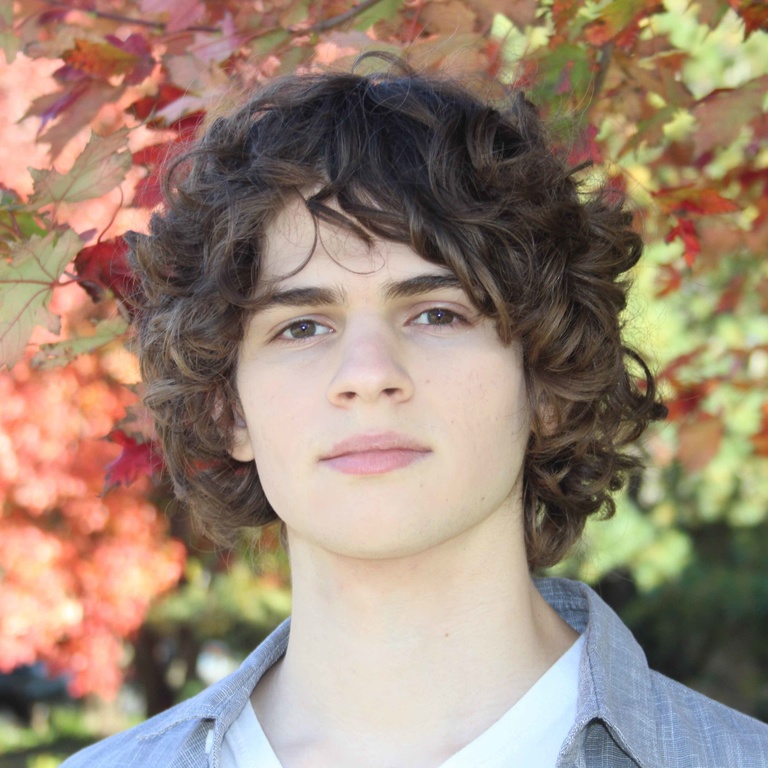 a white man with shaggy brown hair looking directly into the camera 