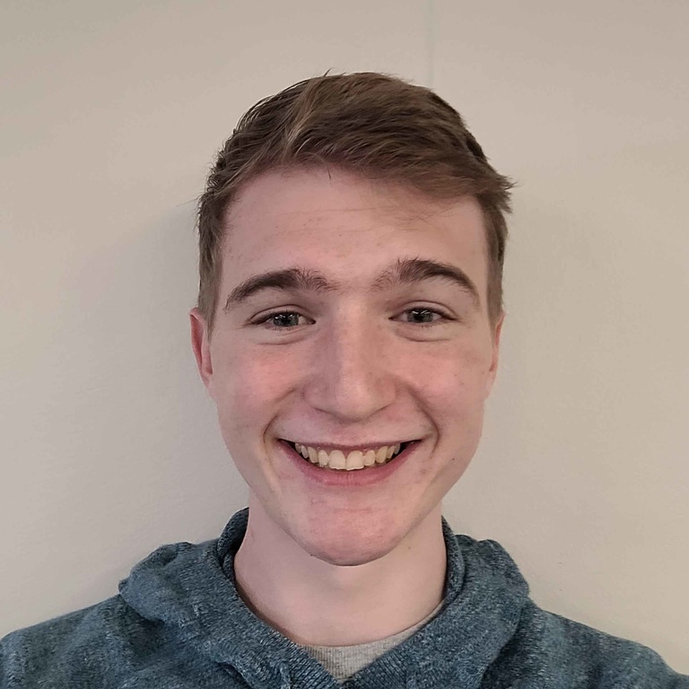 A white man with brown hair and smiling